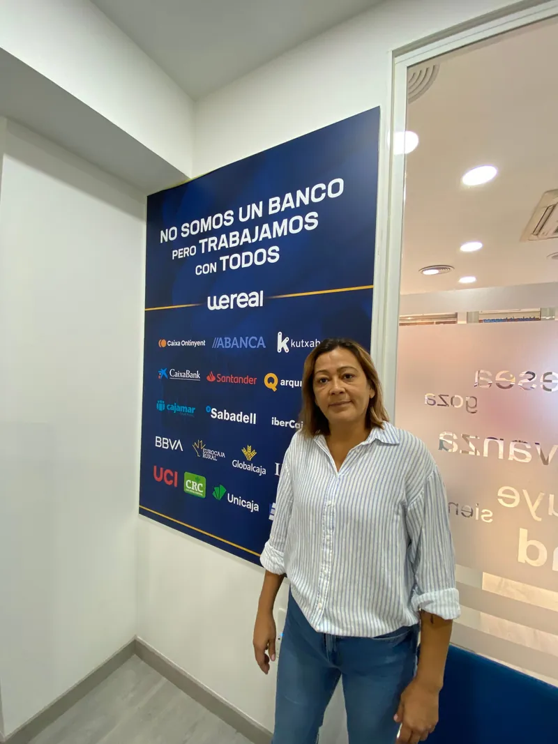 Josy Ribeiro Pereira junto al panel «No somos un banco pero trabajamos con todos» de Wereal